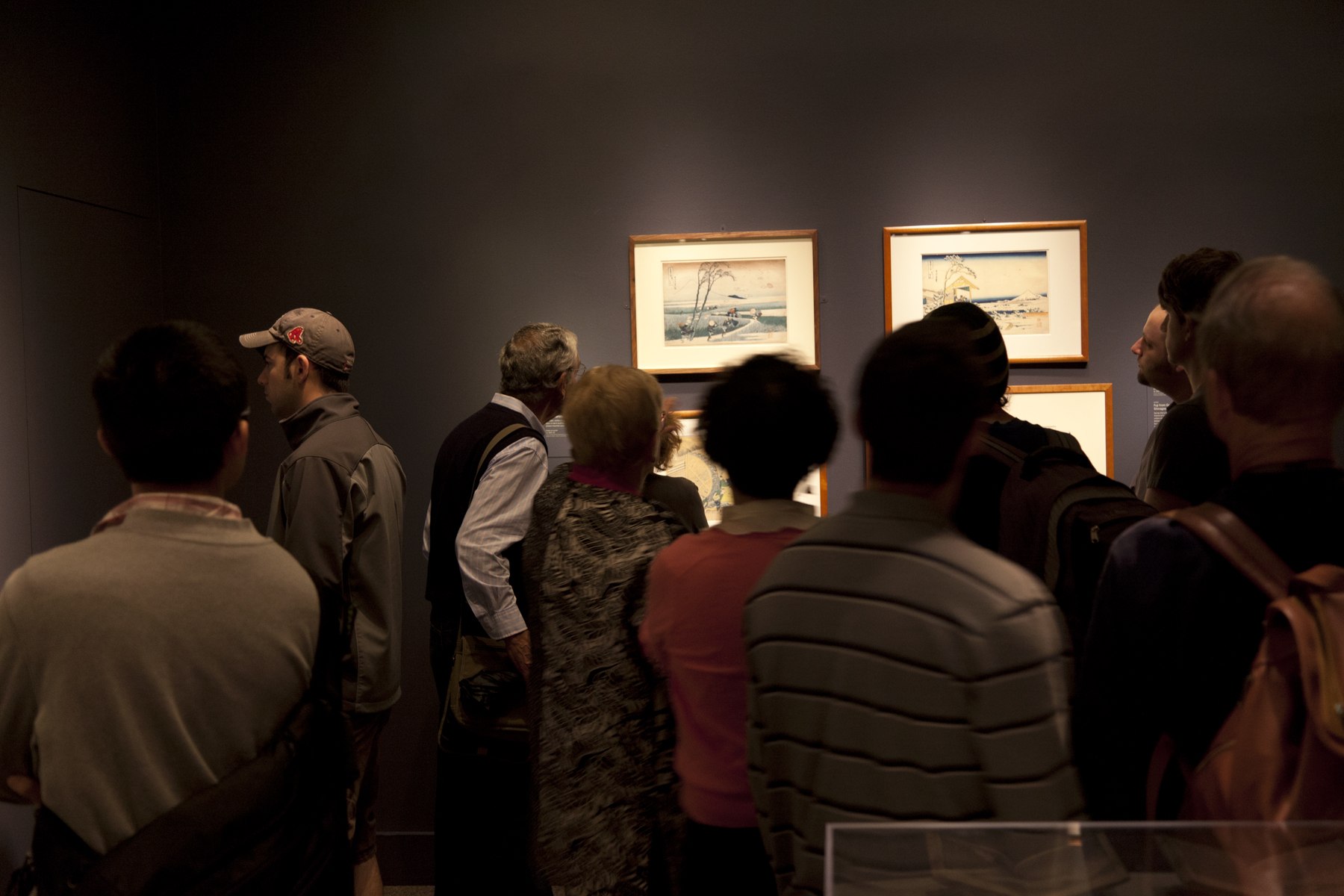 photo of visitors in a room looking at art on a wall