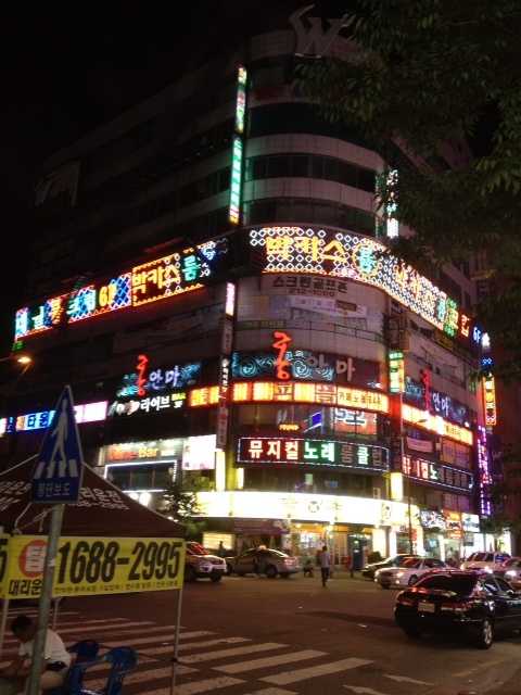 A multi-story building with lit up text.