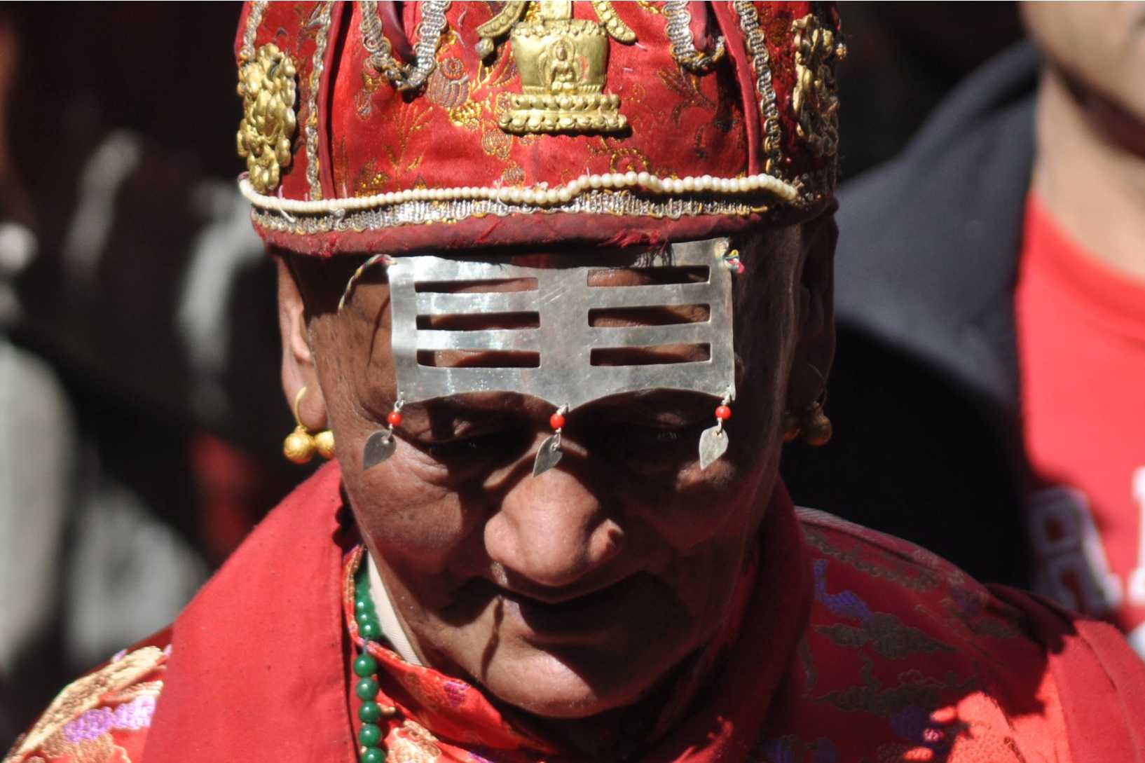 Close up of a man in red ceremonial dress.