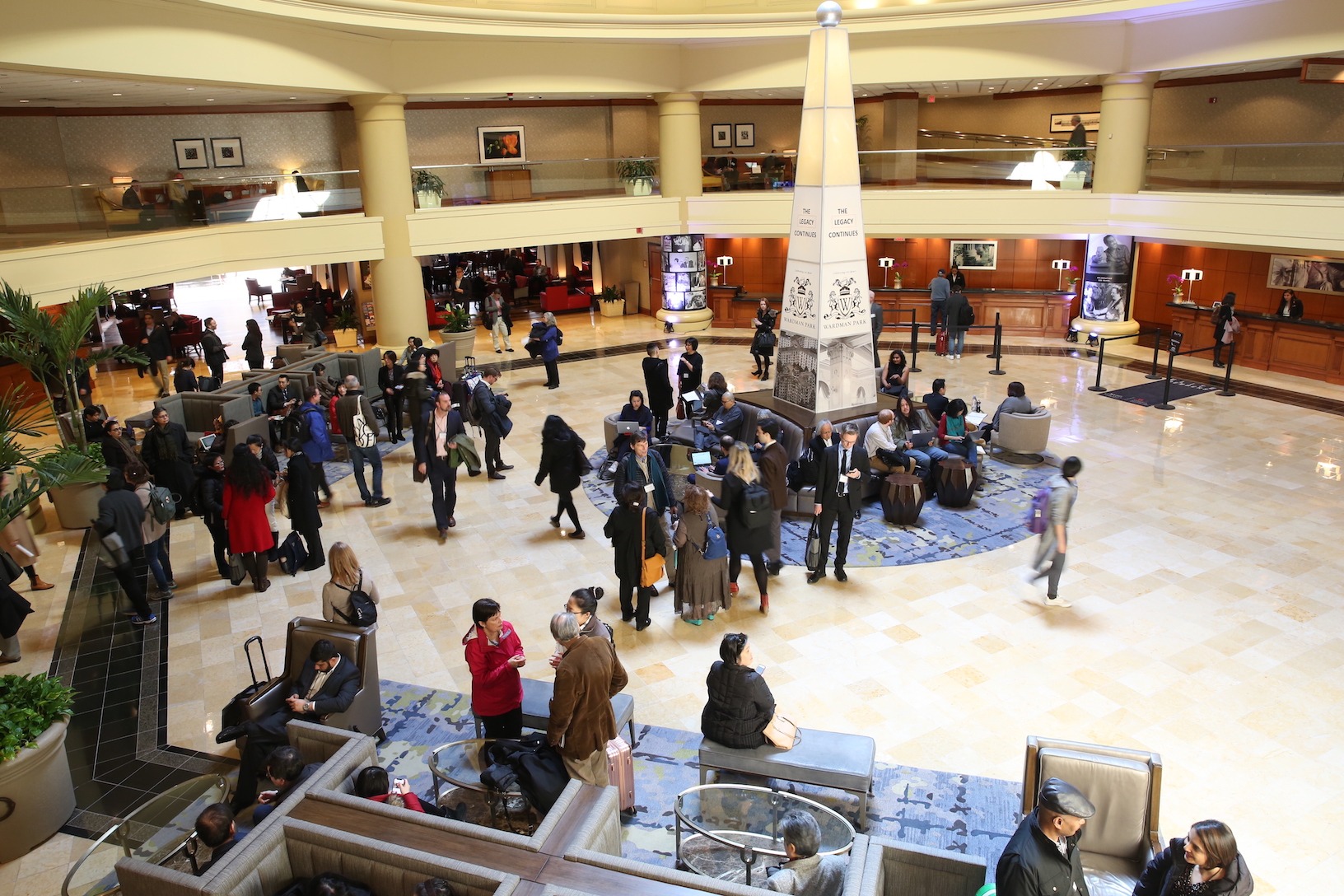 Birds-eye-view of a crowd of people in a hotel lobby.