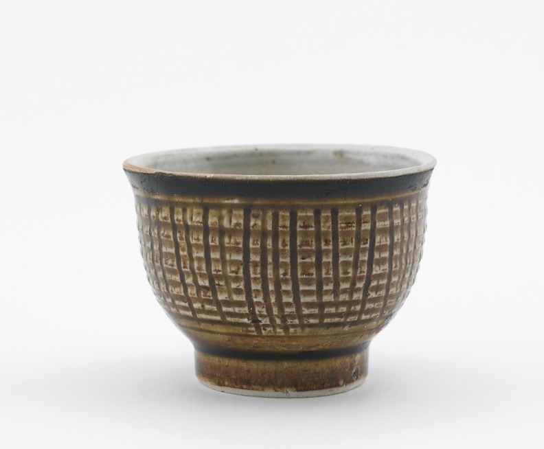 Side view of short rounded wine cup vessel decorated with vertical lines.