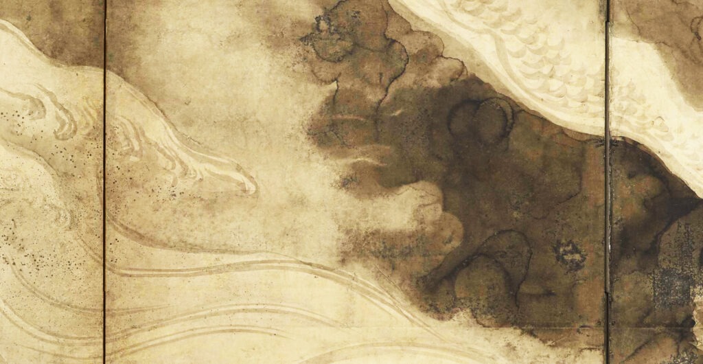 A close-up view of washes of black ink in different tones and textures on a light brown ground.