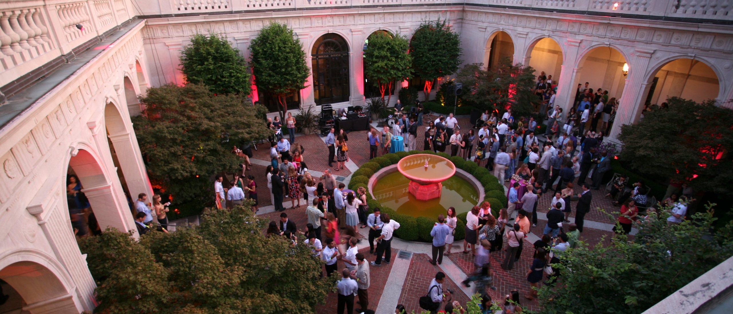 A top-down view of a crowd of people dressed in formal attire standing in a courtyard.