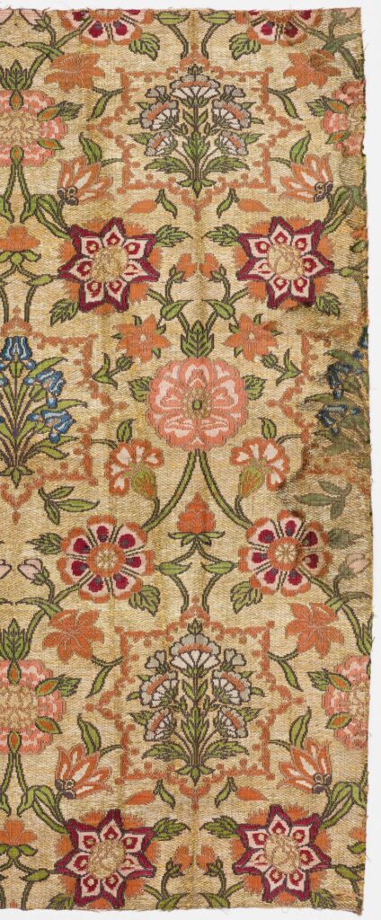 Embroidered textile with a colorful floral pattern against a gold background.