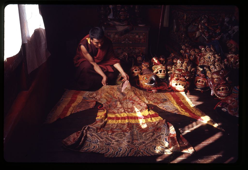 a monk laying out a brocade robe