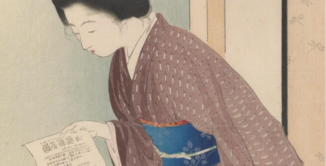 woman in a kimono looking down at a newspaper sheet