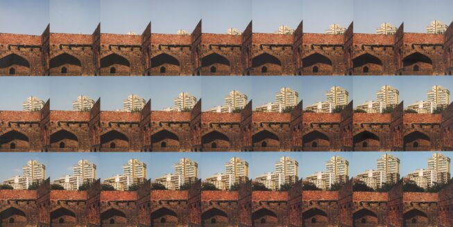 Twenty-seven photographs are arranged in a nine-by-three grid. In the background of each image is a blue sky, and in the foreground of each image is an old red brick wall. Read left to right, the images convey a narrative sequence. On the horizon line, cream-colored modern high-rise buildings appear to emerge upward step-by-step from behind the red brick.
