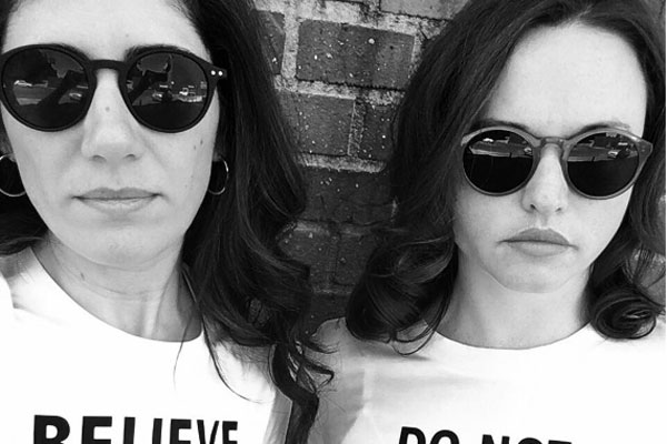 two women wearing sunglasses wear shirts that say Believe in the Truth and Do Not Obey in Advance