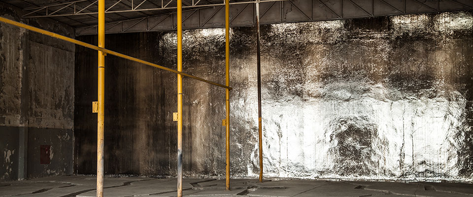 A room with yellow scaffolding, the far back wall all silvery