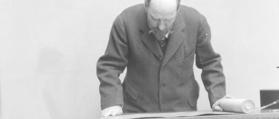 Archival image of Charles Lang Freer reading a scroll.