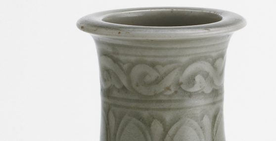 Open tip of glassy greenish-gray vase.