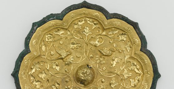 Close up of a golden object with floral designs.