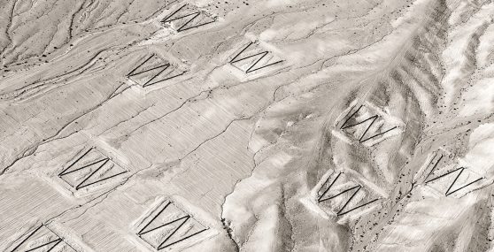 Grey cracked hard substance with imprints of the letter W throughout.