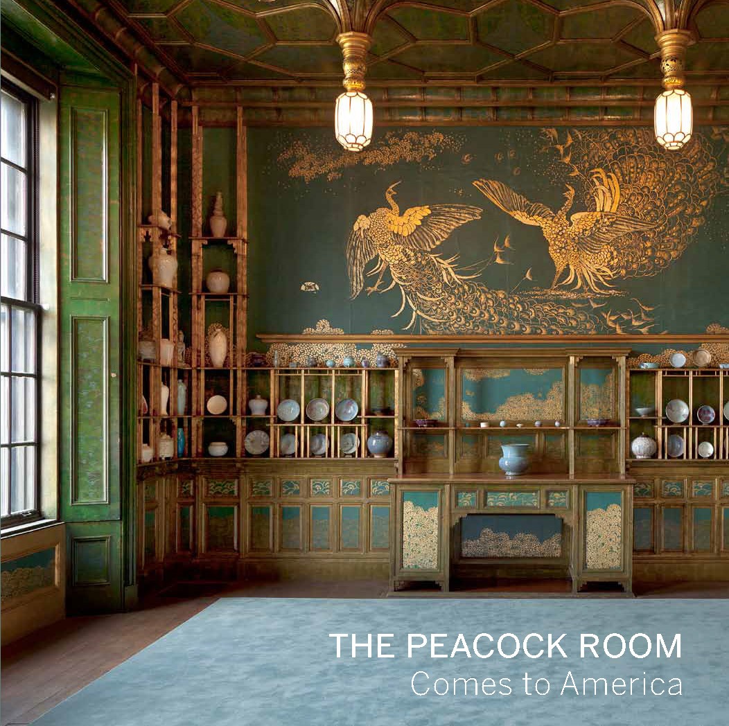 The Peacock Room Comes to America book cover featuring detail of the Peacock Room. Light streams in from windows on the left, the green shutters open. On the far wall is a painting of two golden peacocks fighting against a green background. The painting is surrounded by shelves of ceramics.