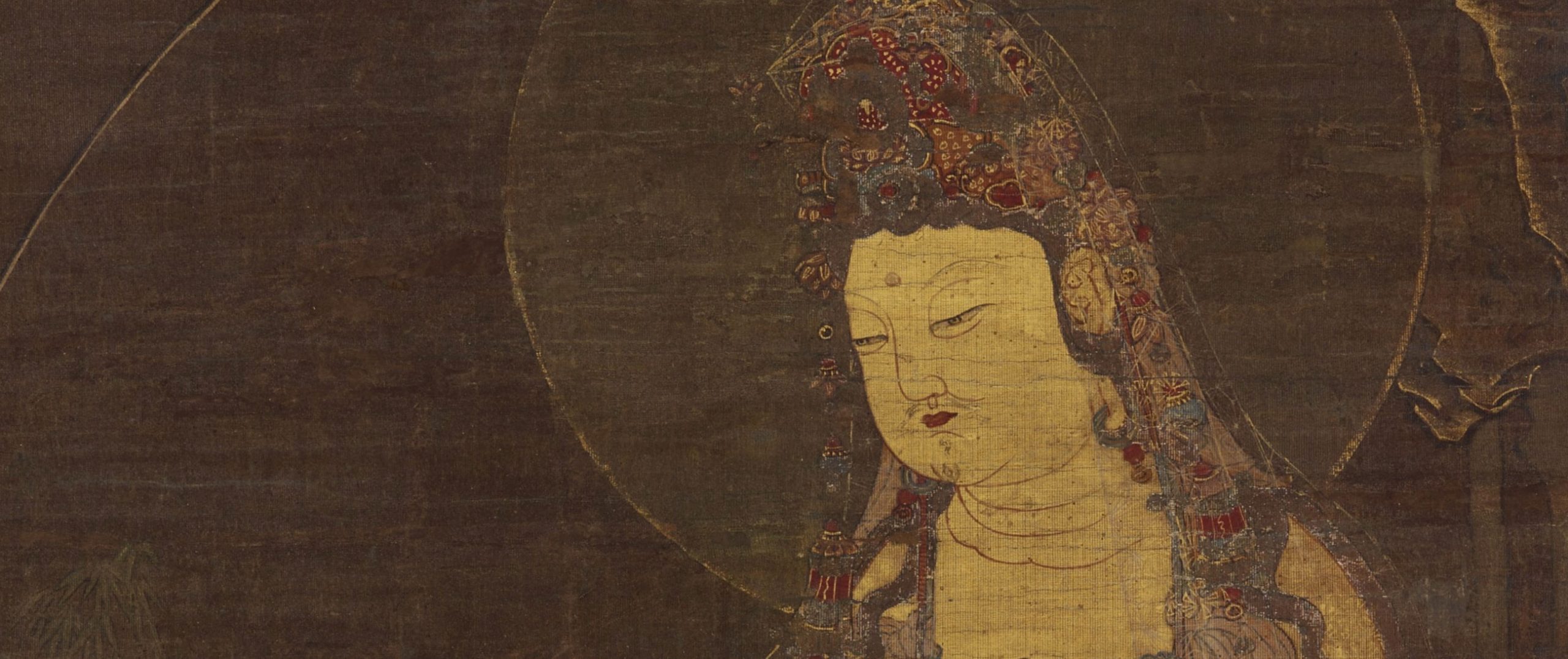 head and shoulders of a round faced figure wearing an elaborate headdress with a pale gold halo