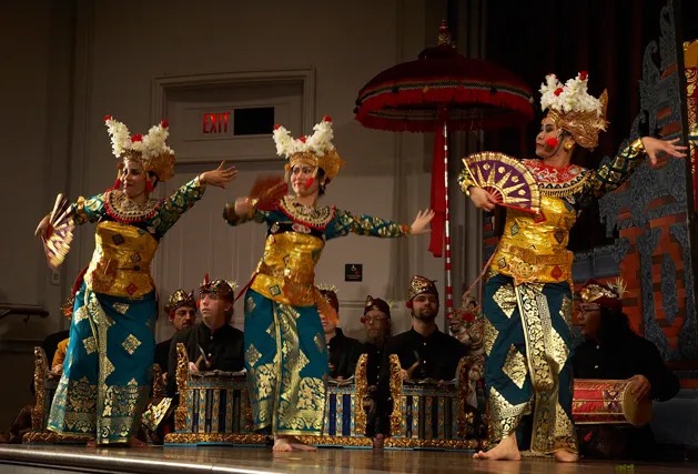 Three gamelan dancers posing, holding fans