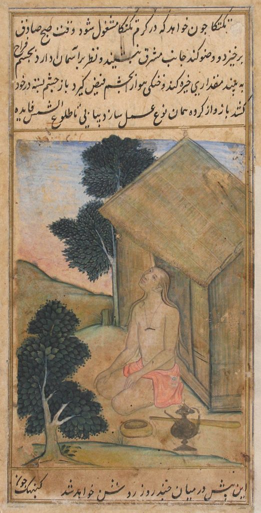 Man kneeling in front of a hut and looking up.