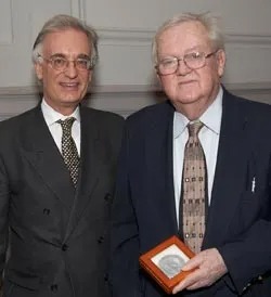 Two men, one holding a Freer medal in a box