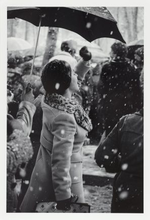 Black and white photo of a protester under an umbrella in the snow