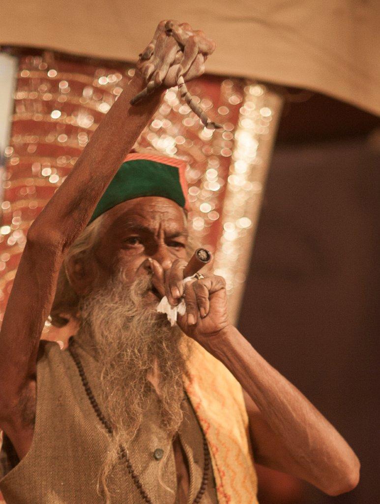 a man holding his arm in the air while smoking a pipe with the other arm