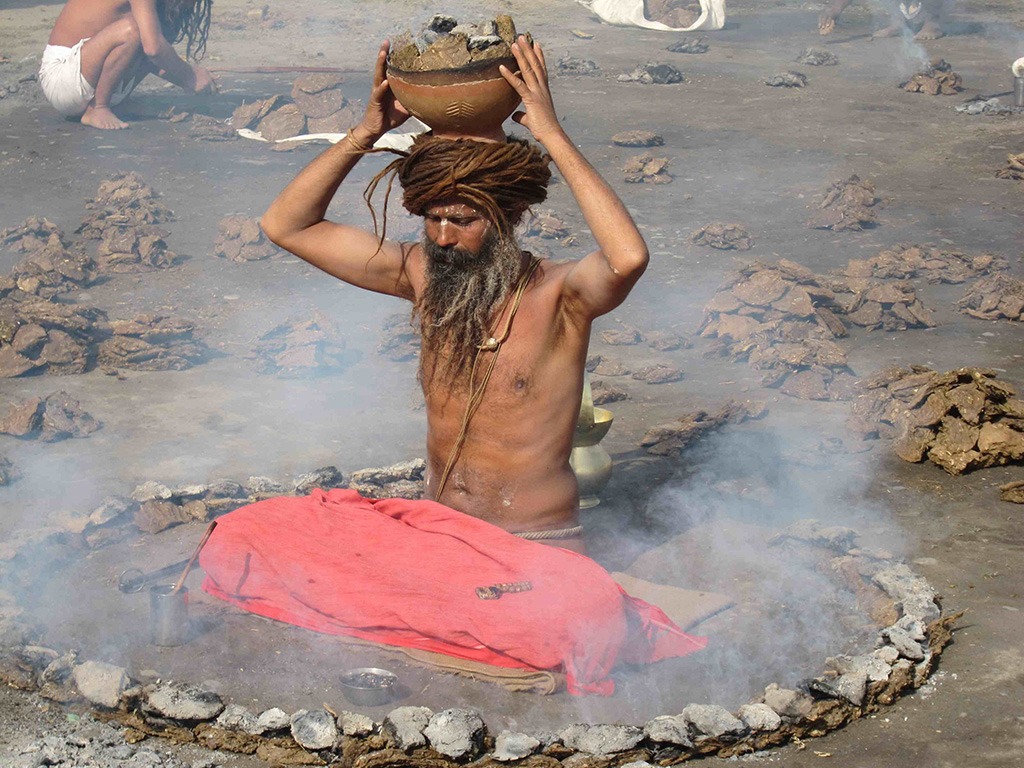 yogi sitting with pot over his head