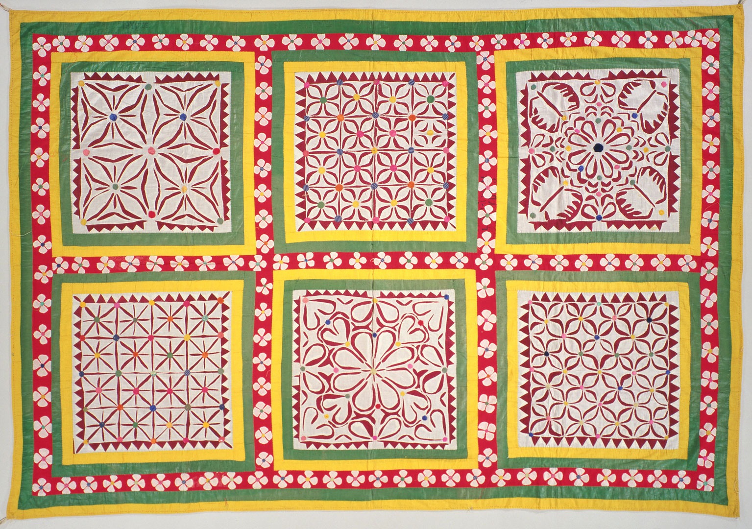 A brightly colored textile with 2 rows of 3 squares filled in with lively patterns.