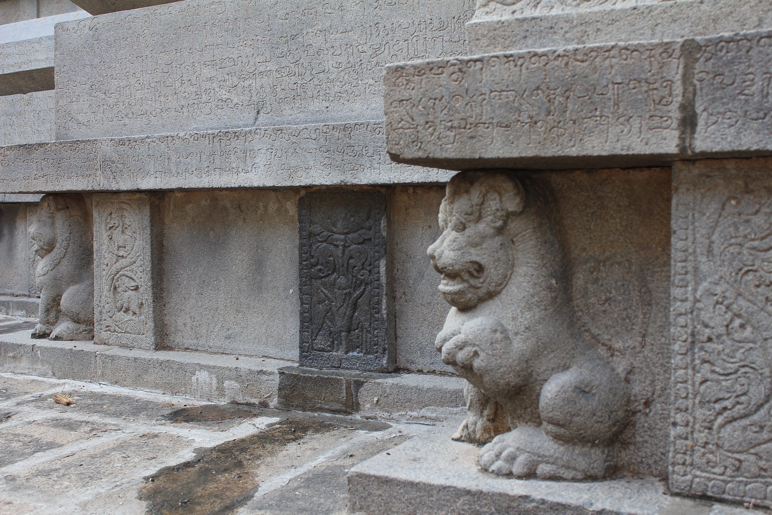 Lion sculpture supporting the base of a granite temple