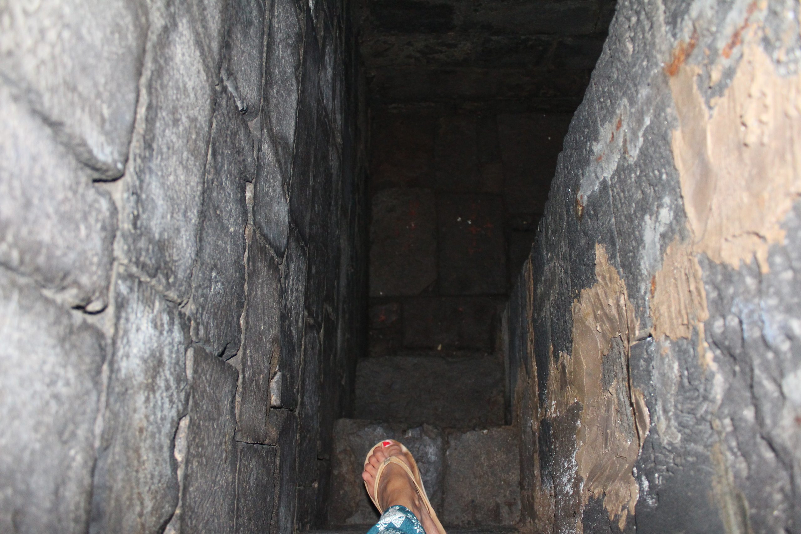 Foot stepping down narrow stone steps