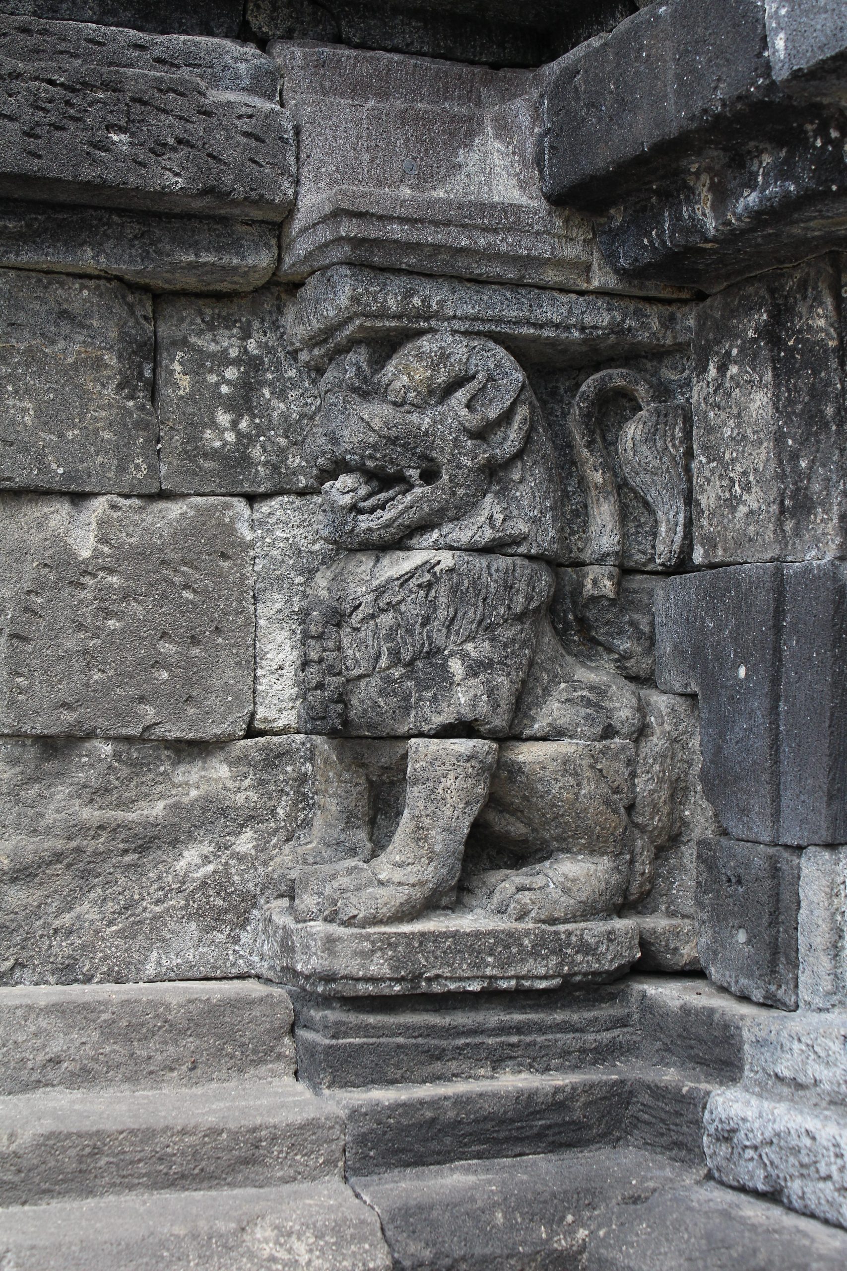 Lion sculpture supporting the base of a granite temple