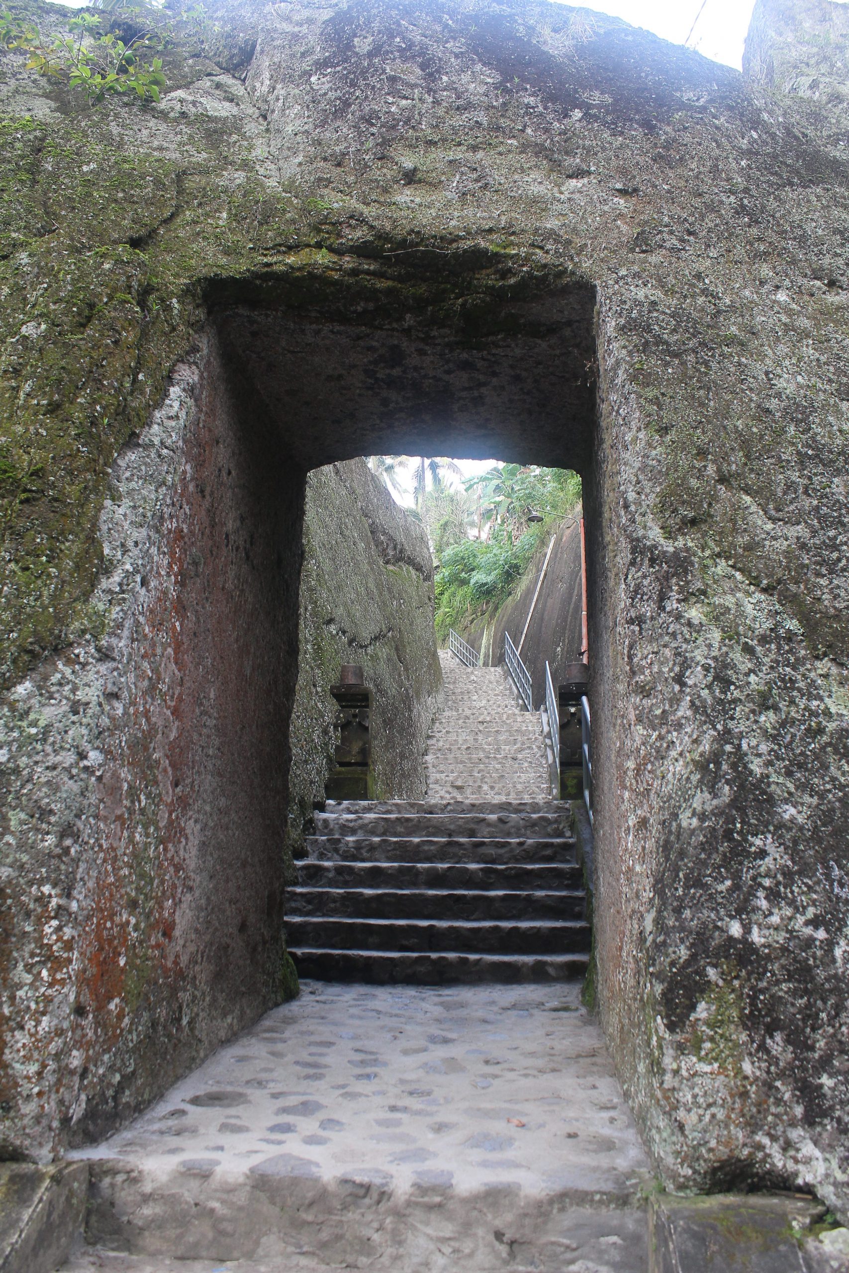 Stairs and paved path through rock cut door