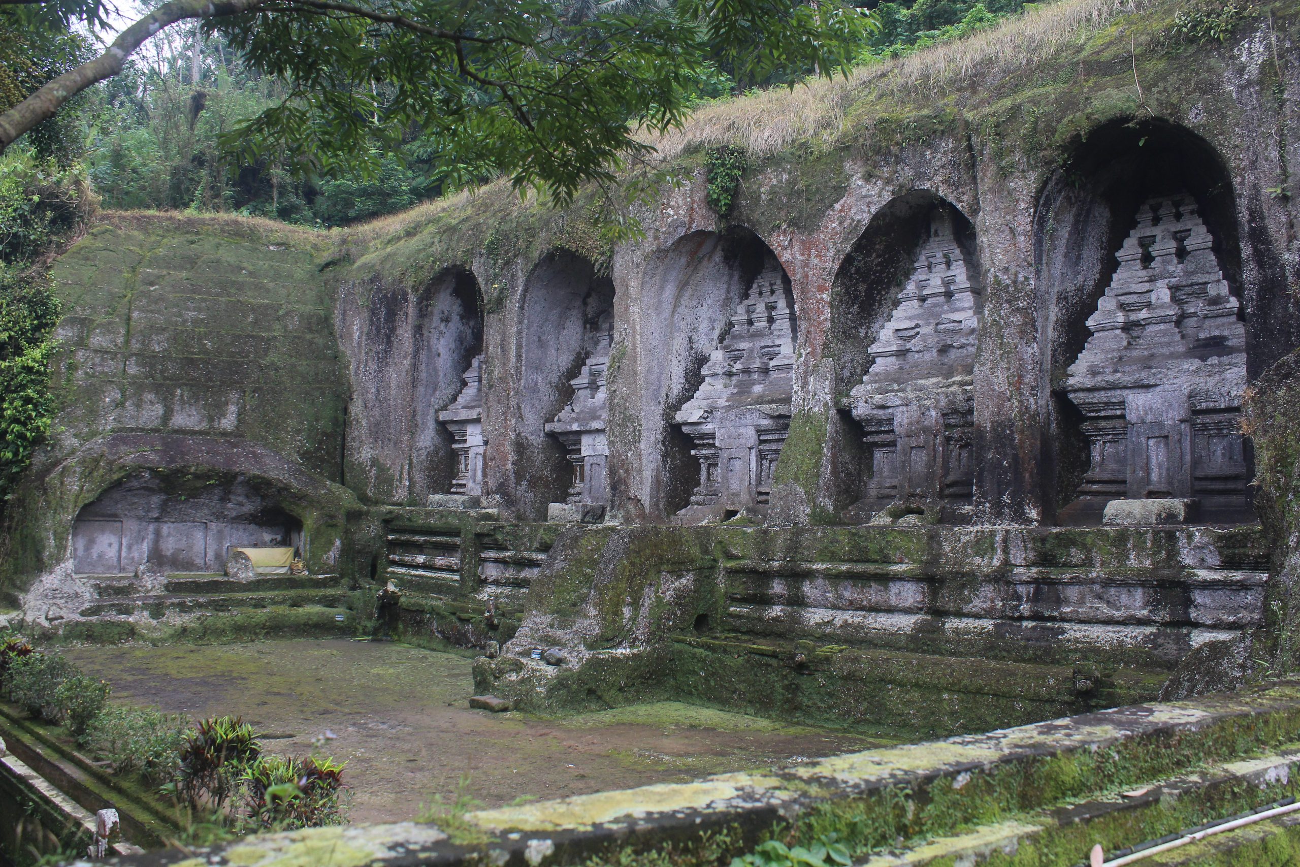 Empty pool in front of monumental candis in rock face, seen obliquely