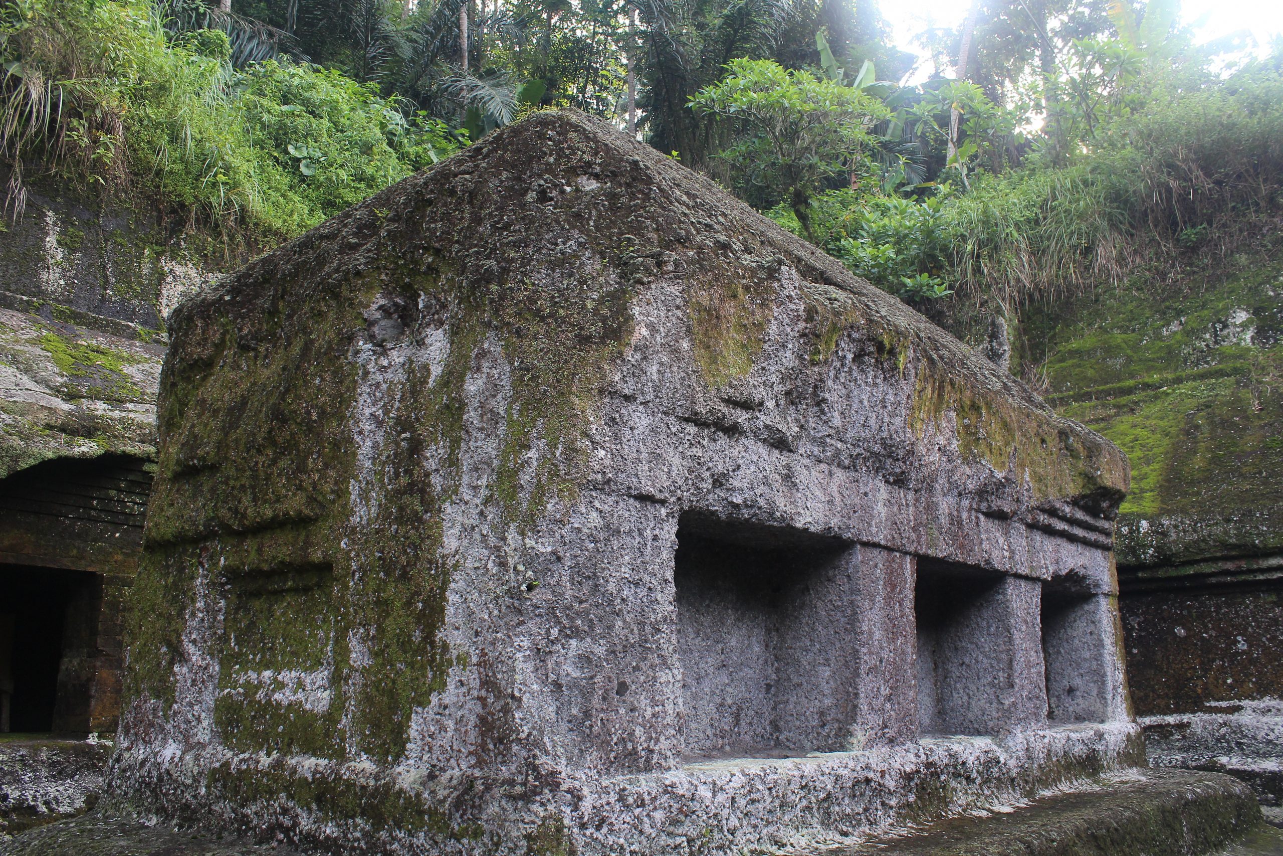 Rock-cut shrine, partially ruined, with caves