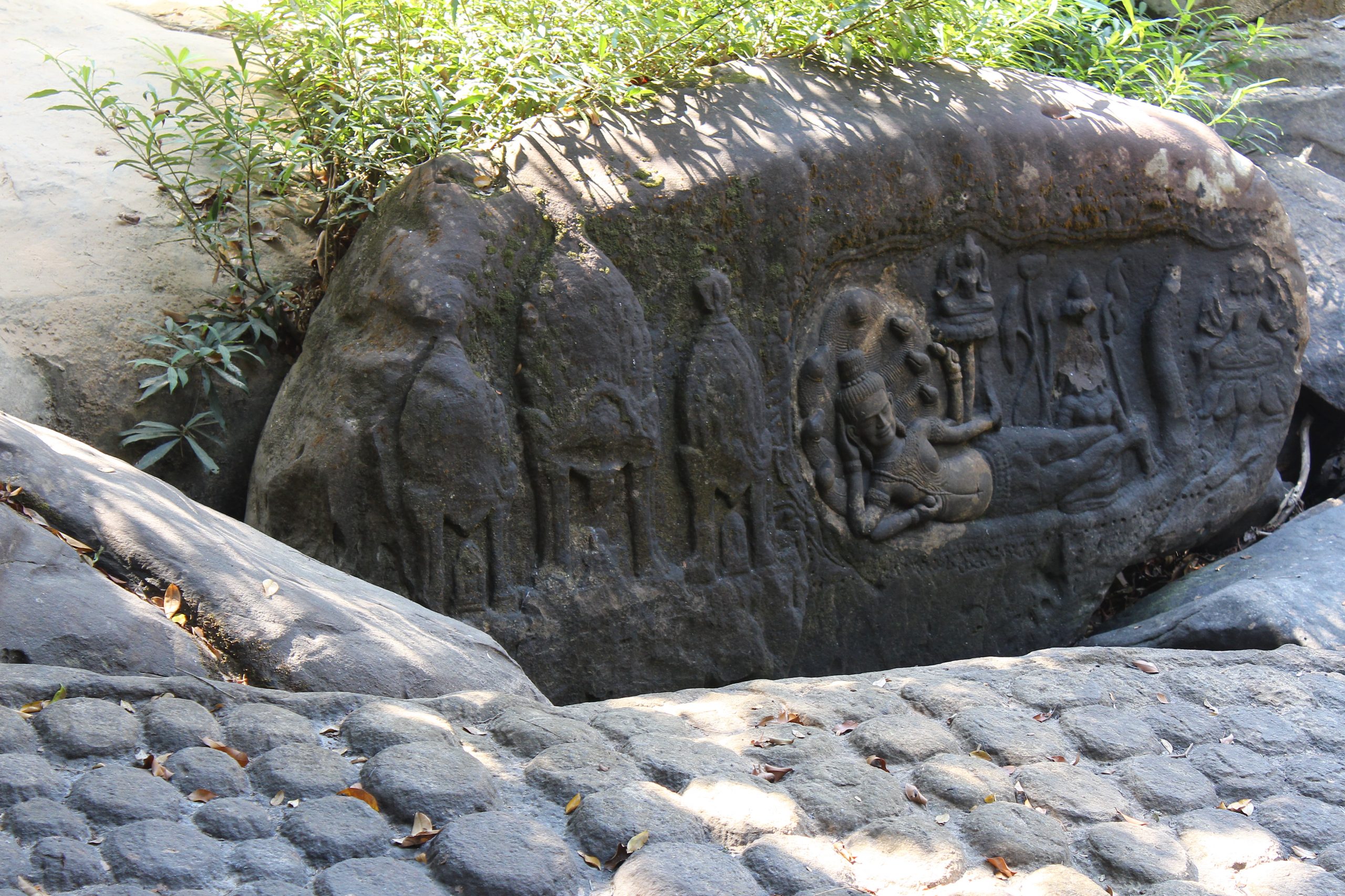 Relief carving of Vishnu reclining with three shrines, carved into the living rock