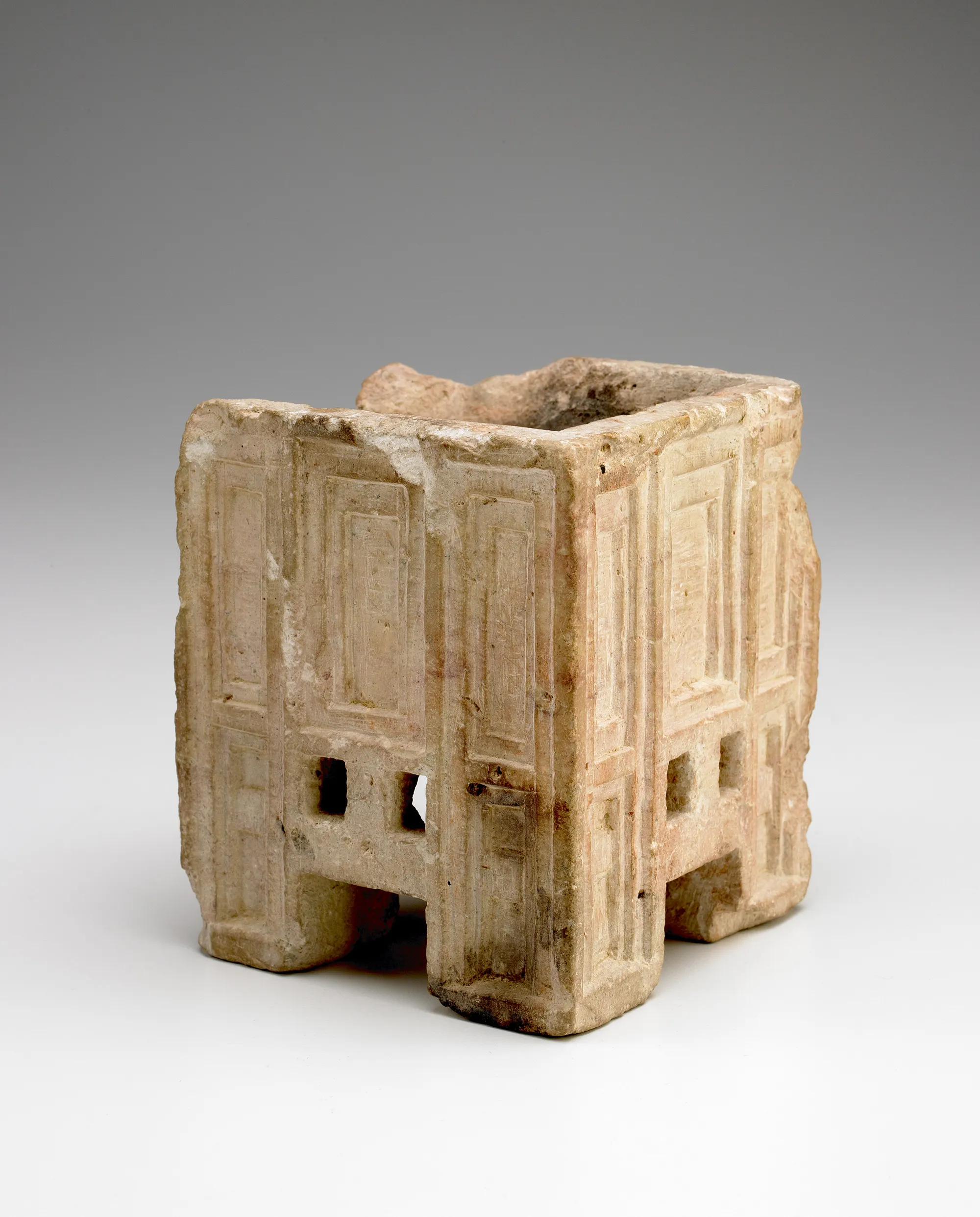 a square carved container, broken on one side