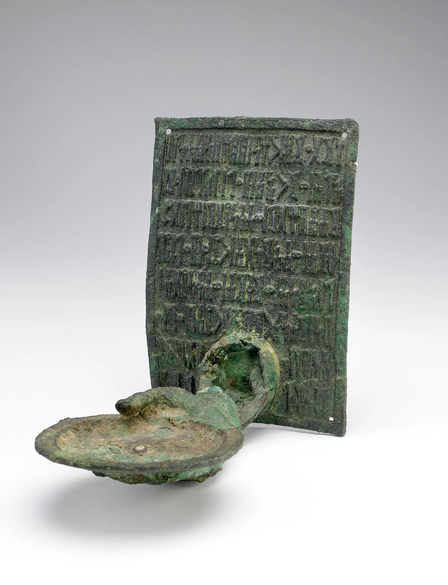 a flat, inscribed metal plate and a elongated oval object with a handle