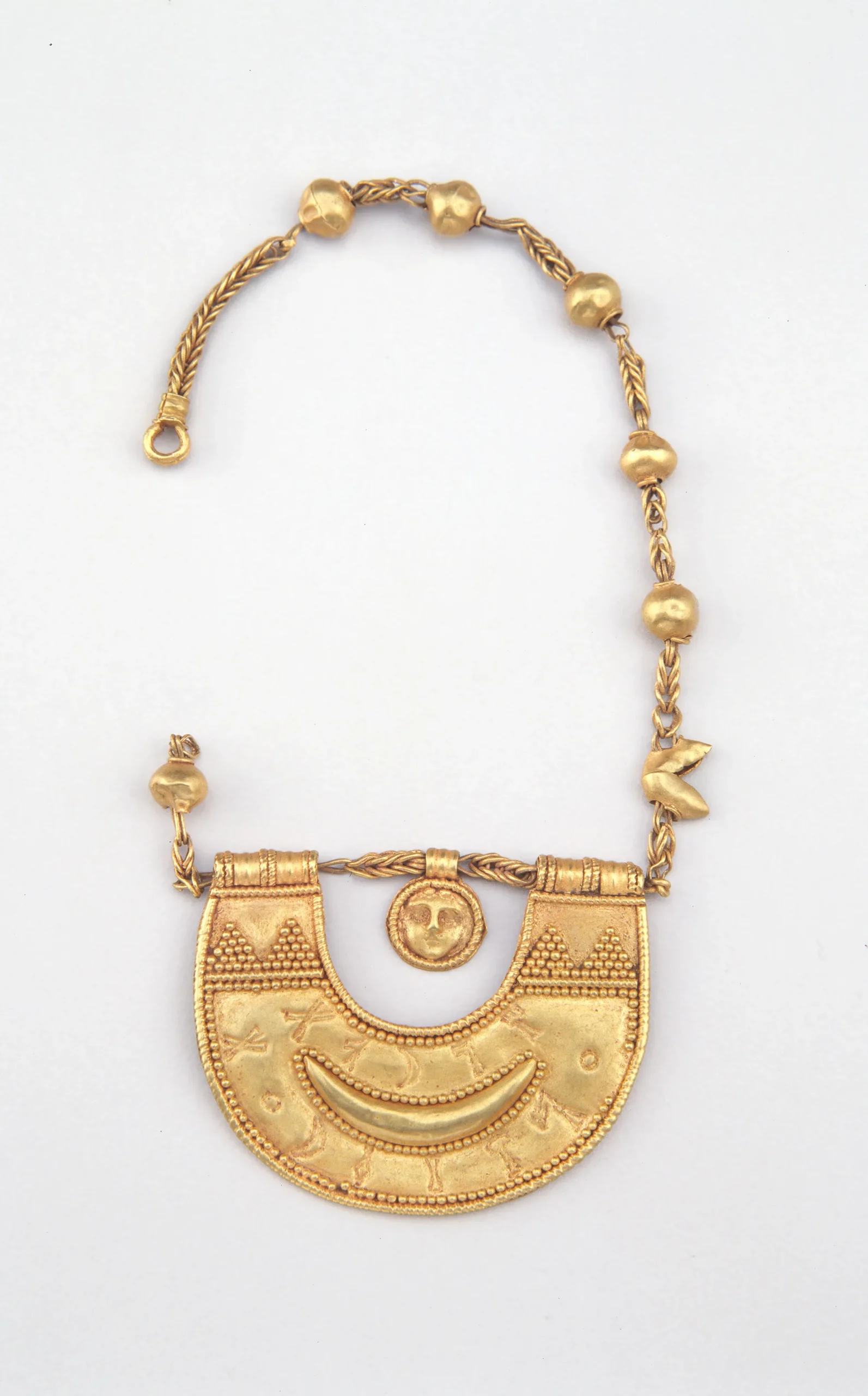 golden ornament with beaded fastening and half-circle decorated lower half