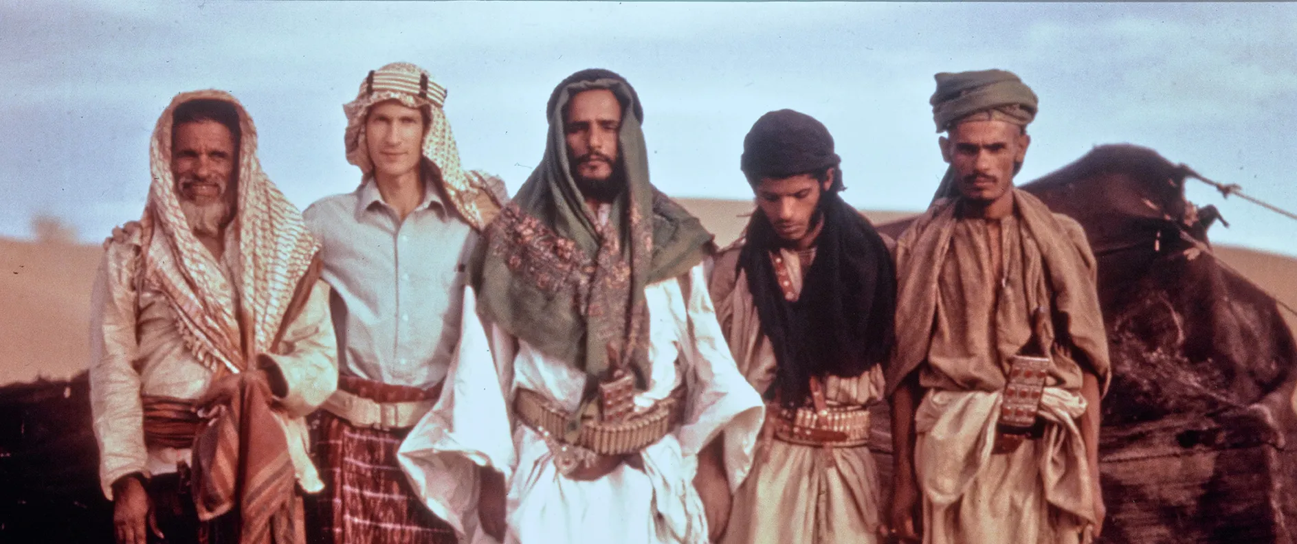 an archival photograph of five men standing in a row