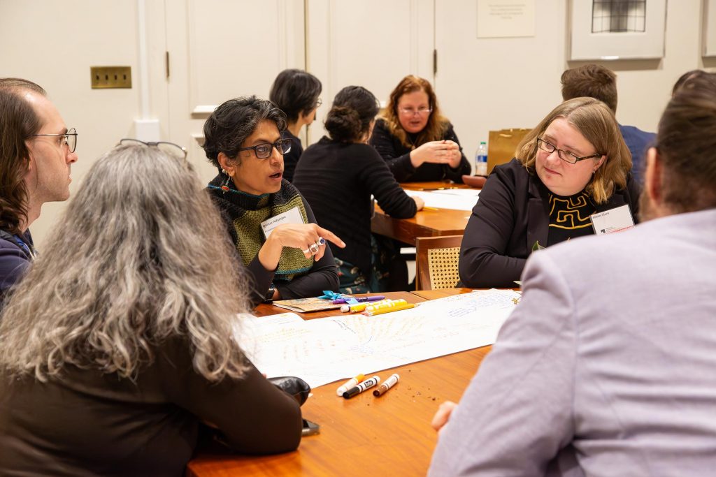 A group of researchers, gathered around the table, in the midst of discussion.