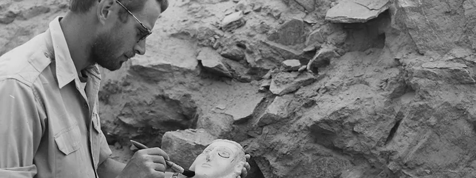 a man using a brush to clean a sculptured head