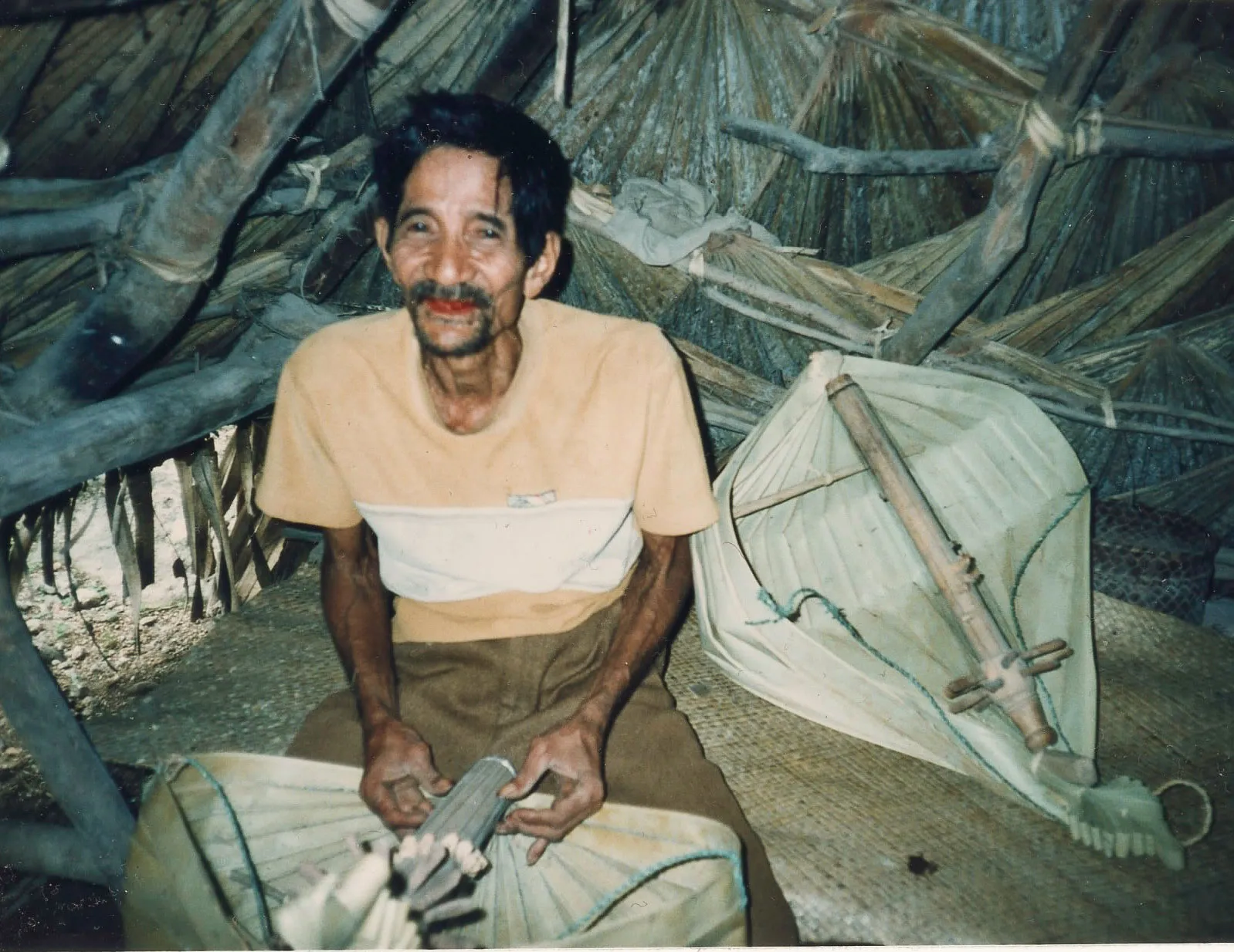 A man seated on the floor playing sasando biola