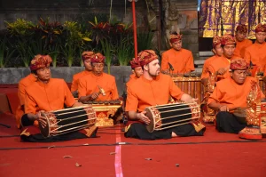 A row of kendang drummers in front of a row of gangsa jonkok players.