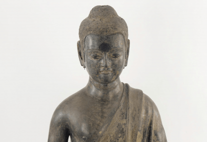 Dry lacquer figure depicting the Sakyamuni Buddha sitting dressed in a robe with hands missing and long earlobes broken off.