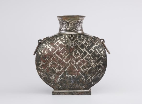 Metal vessel with swirling designs.