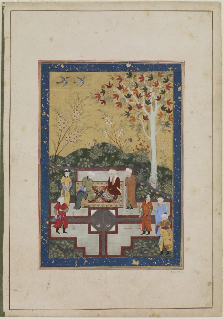 an elderly woman and two men gathered in a garden, kneeling on a rug