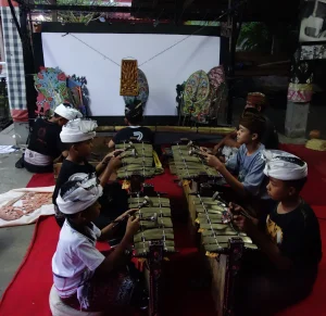 Four children playing wooden bells with mallots, in two rows, facing each other.