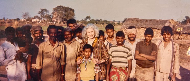 Elizabeth Moynihan posing for a photo with a group of Indian locals