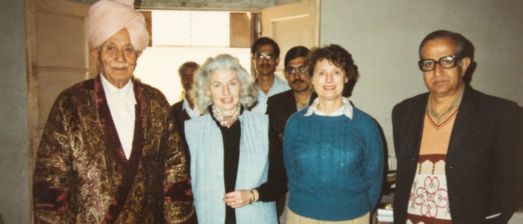 a group of two women and five men posing for a photograph