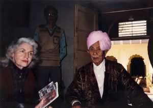 photograph of a woman and two men, one is wearing a brocade turban in a room