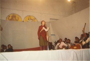 photograph of a woman singing at a gathering