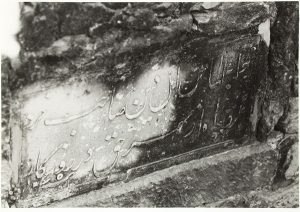 photograph of a well with a plaque bearing a Persian inscription